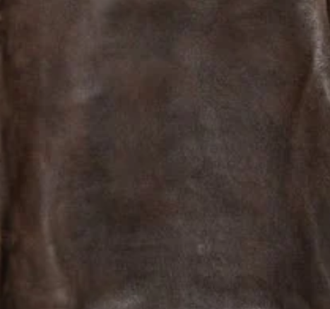 A close-up of a dark brown textured material, showing a soft suede or leather-like surface.